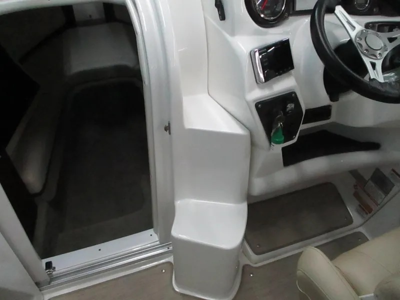 Slide: The Image of 2018 Rinker QX29 CC cabin interior with white seating and porthole. - 9