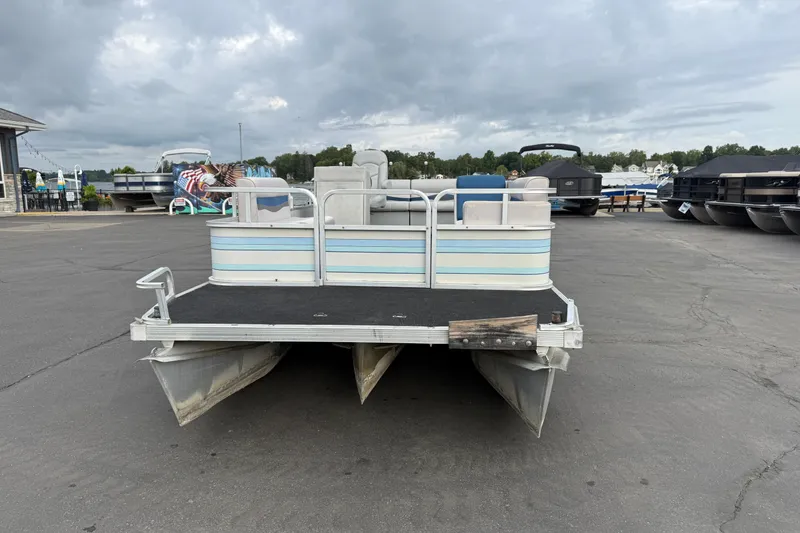 Slide: The Image of 1989 Riviera Cruiser Fun Deck 22 pontoon boat on a dock under cloudy skies. - 1