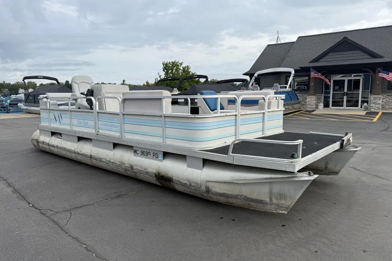 Slide: The Image of 1989 Riviera Cruiser Fun Deck 22 pontoon boat parked outside a building. - 3