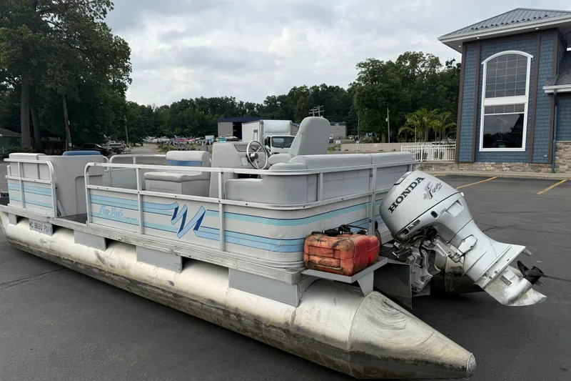 Slide: The Image of 1989 Riviera Cruiser Fun Deck 22 pontoon boat with Honda outboard motor in parking lot. - 6