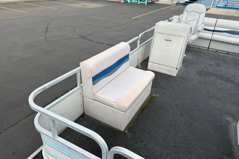 Slide: The Image of 1989 Riviera Cruiser Fun Deck 22 with white seating and blue accents on a docked pontoon boat. - 7