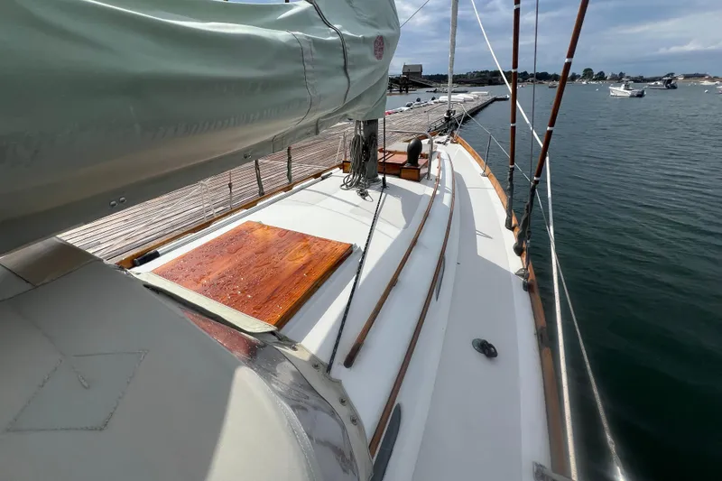 Slide: The Image of Hinckley Pilot 35 Sloop, 1964, docked with covered sails, wooden deck details, and calm waters. - 14