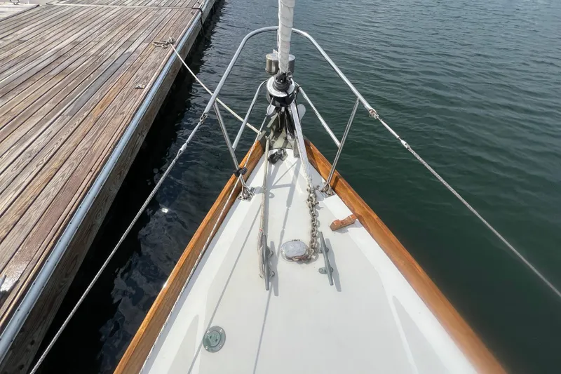 Slide: The Image of Hinckley Pilot 35 Sloop 1964 bow view, docked, showcasing deck and railing details. - 16