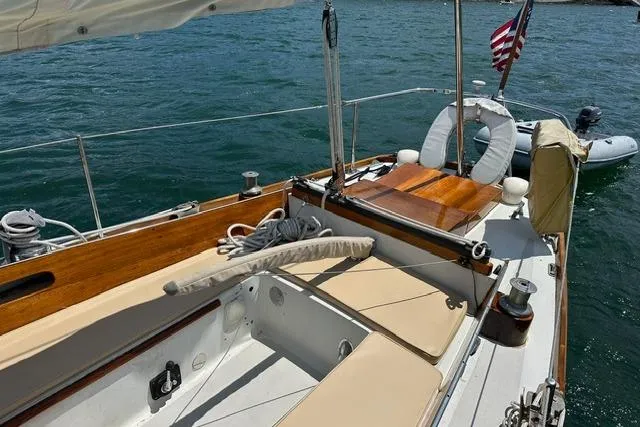 Slide: The Image of 1964 Hinckley Pilot 35 Sloop sailboat with wooden deck and American flag on water. - 21