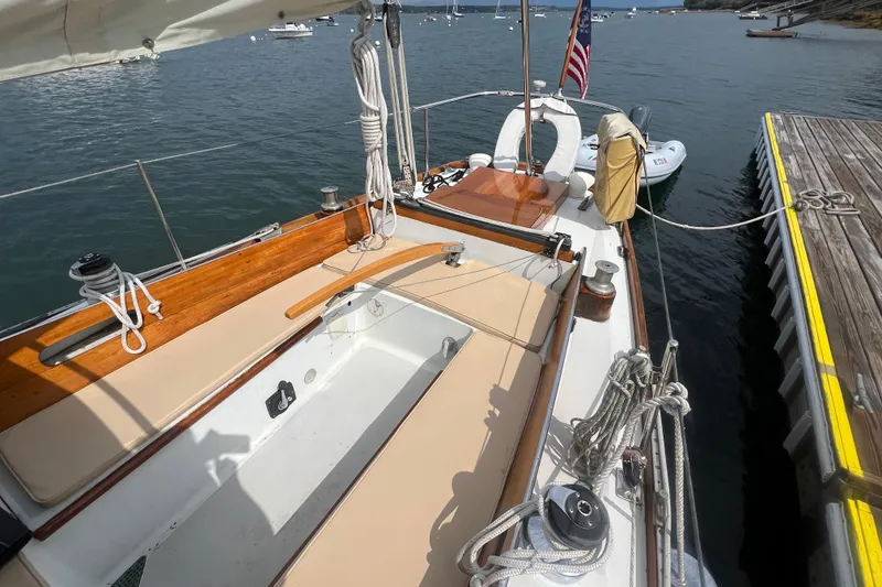Slide: The Image of 1964 Hinckley Pilot 35 Sloop docked, showcasing deck and seating area. - 22