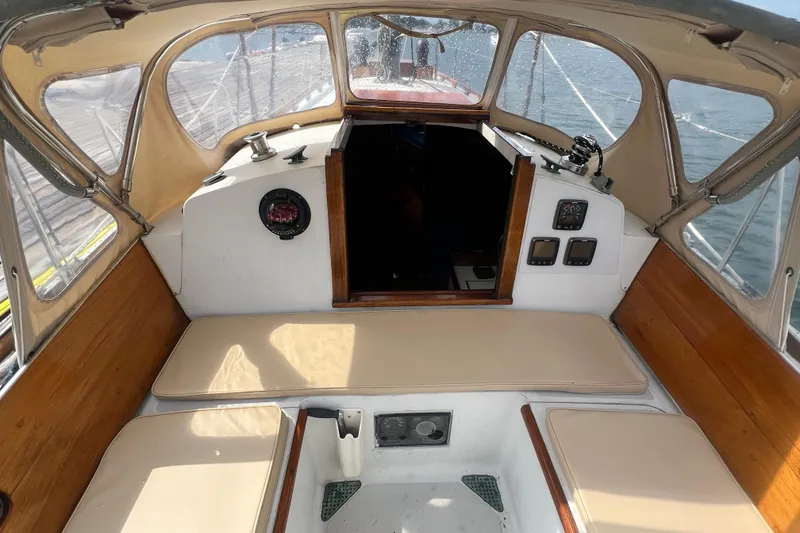 Slide: The Image of 1964 Hinckley Pilot 35 Sloop cockpit with beige seating and wooden accents. - 23