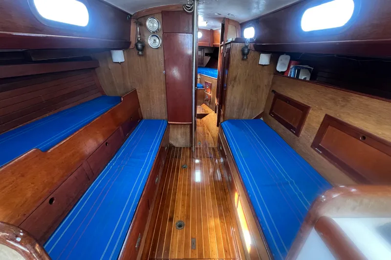 Slide: The Image of Interior of 1964 Hinckley Pilot 35 Sloop with blue cushions and wooden finish. - 3