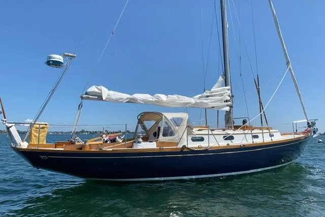 Slide: The Image of 1964 Hinckley Pilot 35 Sloop sailing yacht on calm waters under clear blue sky. - 34