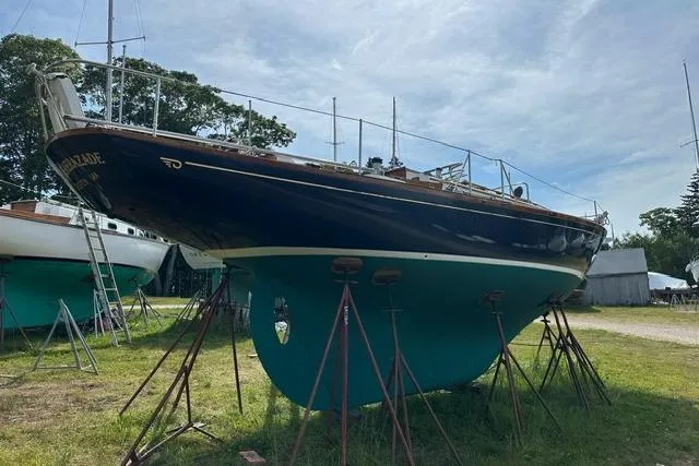 Slide: The Image of 1964 Hinckley Pilot 35 Sloop sailboat on stands, displayed outdoors under a clear sky. - 37
