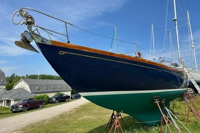 Slide: The Image of 1964 Hinckley Pilot 35 Sloop sailboat on land, blue hull, green bottom, clear sky. - 38