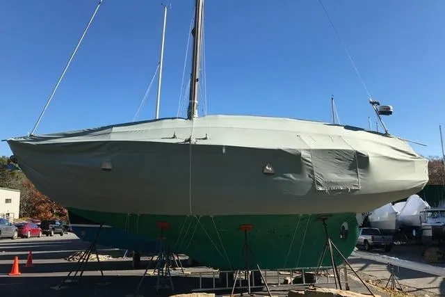 Slide: The Image of 1964 Hinckley Pilot 35 Sloop covered and elevated on stands in a boatyard. - 42