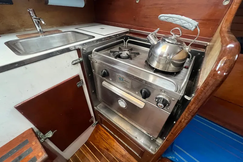Slide: The Image of 1964 Hinckley Pilot 35 Sloop galley with stove, sink, and kettle. - 6