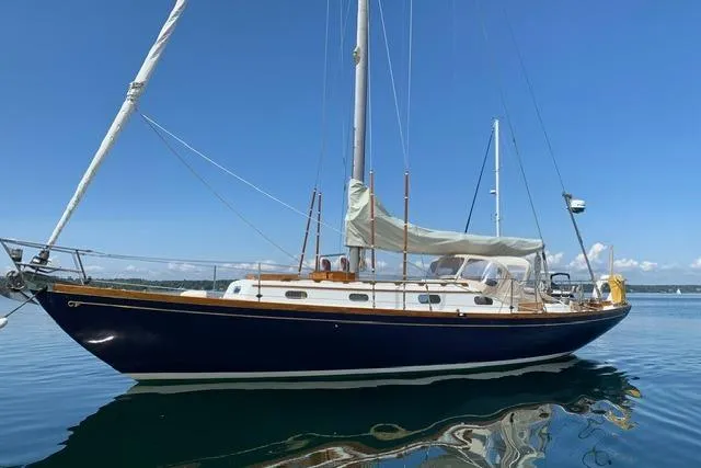 The Image of 1964 Hinckley Pilot 35 Sloop sailing yacht on calm water under clear blue sky. - 0
