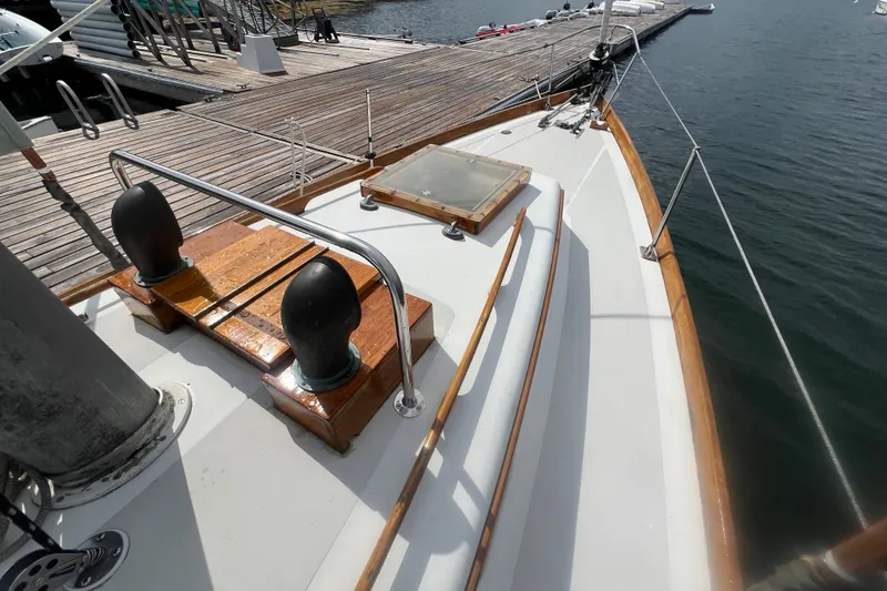 Slide: The Image of 1964 Hinckley Pilot 35 Sloop deck view, showcasing wooden accents and dockside setting. - 15