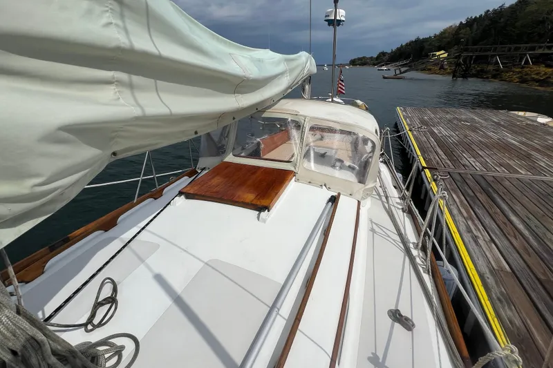 Slide: The Image of 1964 Hinckley Pilot 35 Sloop docked, showcasing deck and sail cover. - 18