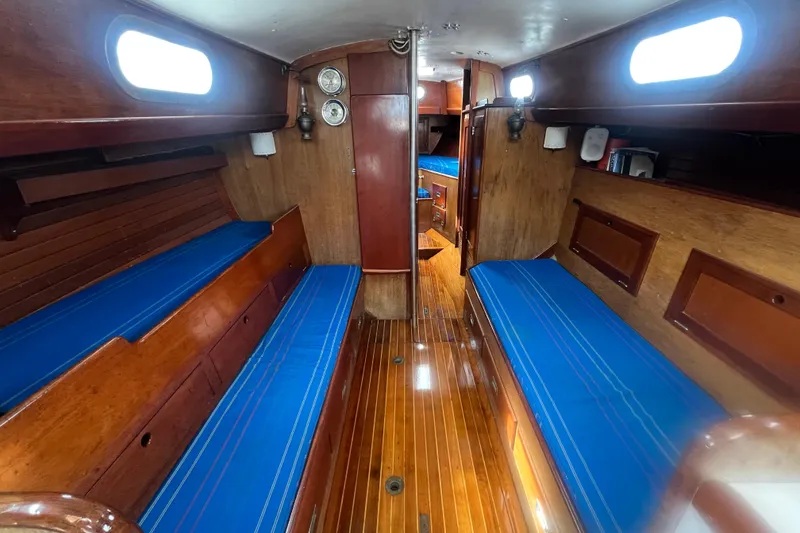 Slide: The Image of Interior of 1964 Hinckley Pilot 35 Sloop with blue cushions and wooden finish. - 2