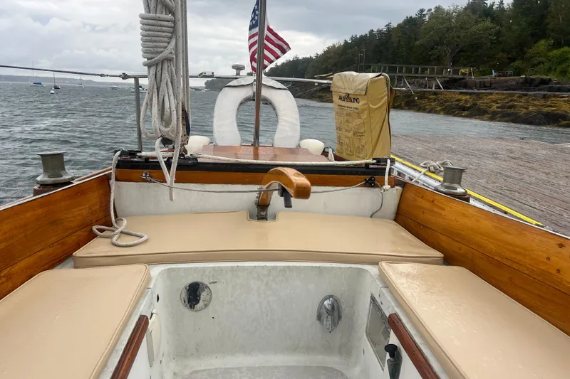 Slide: The Image of Hinckley Pilot 35 Sloop, 1964, with American flag, docked by rocky shoreline. - 27