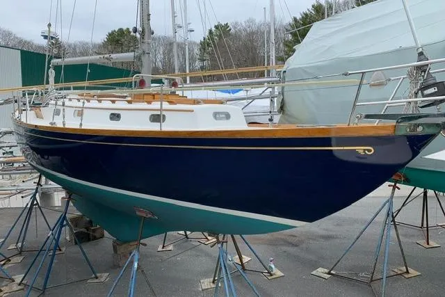 Slide: The Image of 1964 Hinckley Pilot 35 Sloop sailboat on stands, blue hull, classic design. - 40