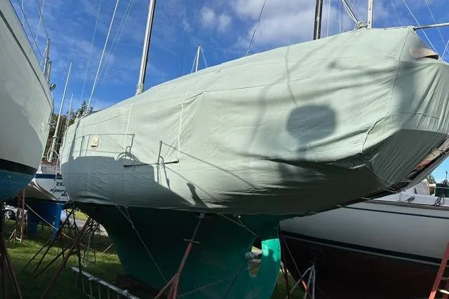 Slide: The Image of 1964 Hinckley Pilot 35 Sloop covered, docked outdoors under blue sky. - 41