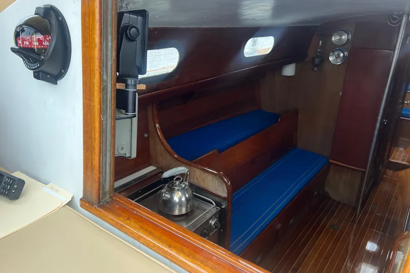 Slide: The Image of Interior of 1964 Hinckley Pilot 35 Sloop with blue cushions and wooden finish. - 8