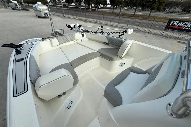 Slide: The Image of 2020 Twin Vee 240 GFX CC boat interior with cushioned seating and fishing rod holders. - 10