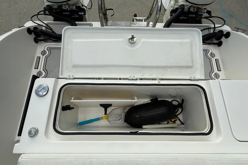 Slide: The Image of Open storage compartment on 2020 Twin Vee 240 GFX CC boat, containing various boating accessories. - 17