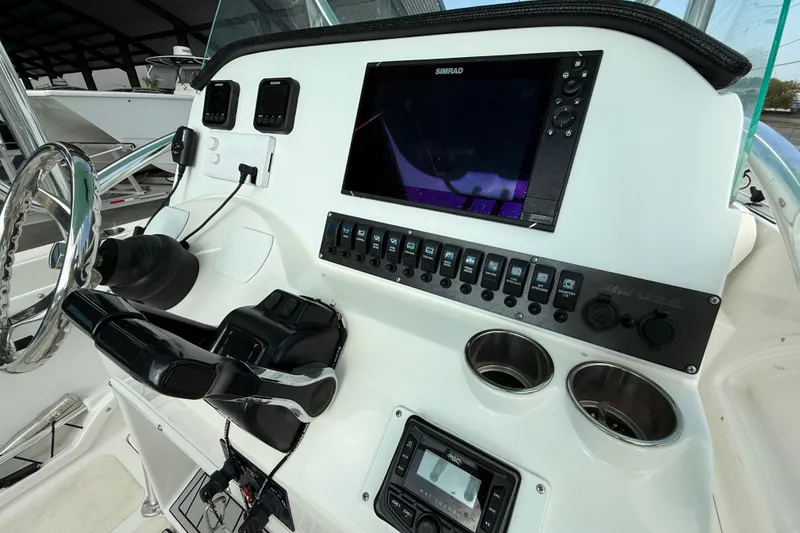 Slide: The Image of 2020 Twin Vee 240 GFX CC boat dashboard with Simrad display and control panel. - 19