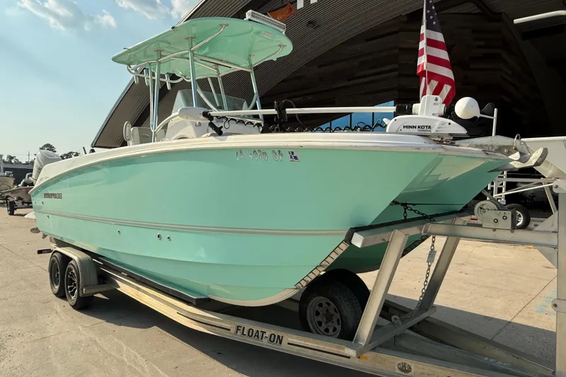 Slide: The Image of 2020 Twin Vee 240 GFX CC boat on trailer, mint green hull, American flag displayed. - 2