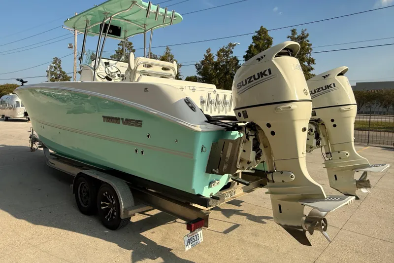 Slide: The Image of 2020 Twin Vee 240 GFX CC boat with dual Suzuki outboard motors on a trailer. - 5