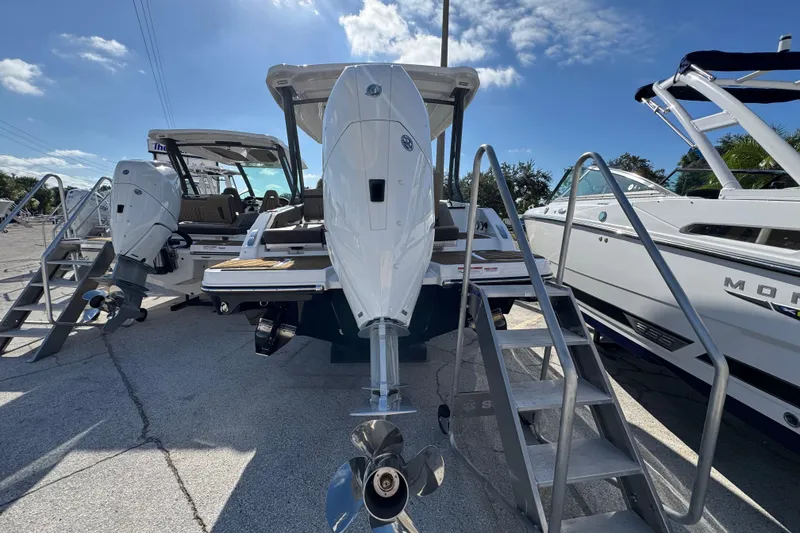 Slide: The Image of 2026 Monterey Elite 27 OB boat with dual outboard engines, docked under a clear sky. - 2