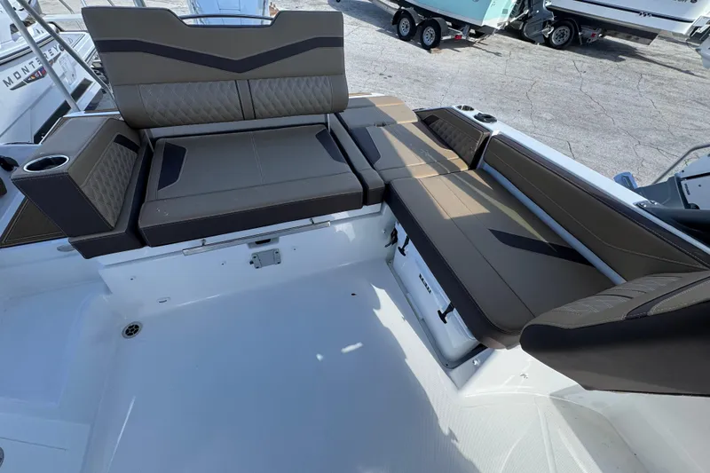 Slide: The Image of 2026 Monterey Elite 27 OB boat interior with brown cushioned seating and cup holders. - 4