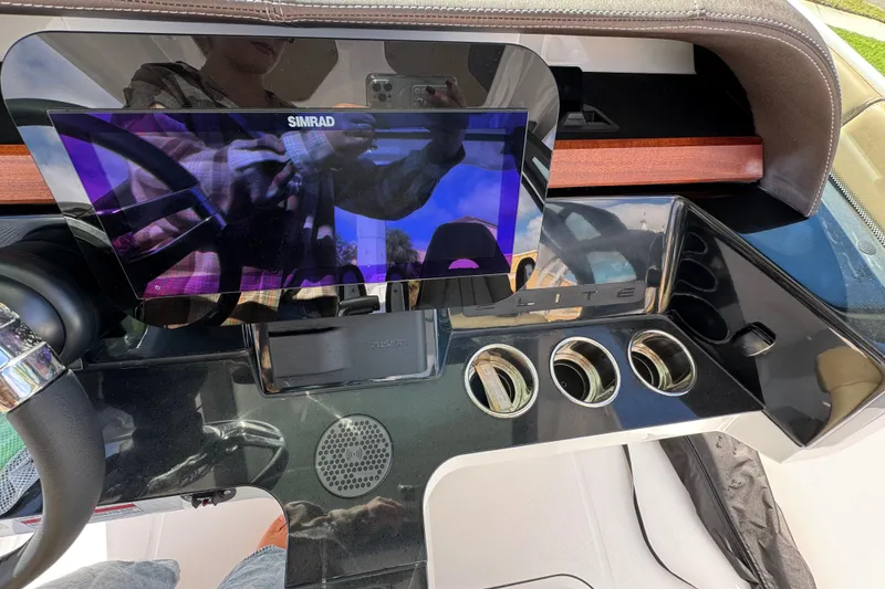 Slide: The Image of 2026 Monterey Elite 27 OB dashboard with Simrad display and cup holders. - 8