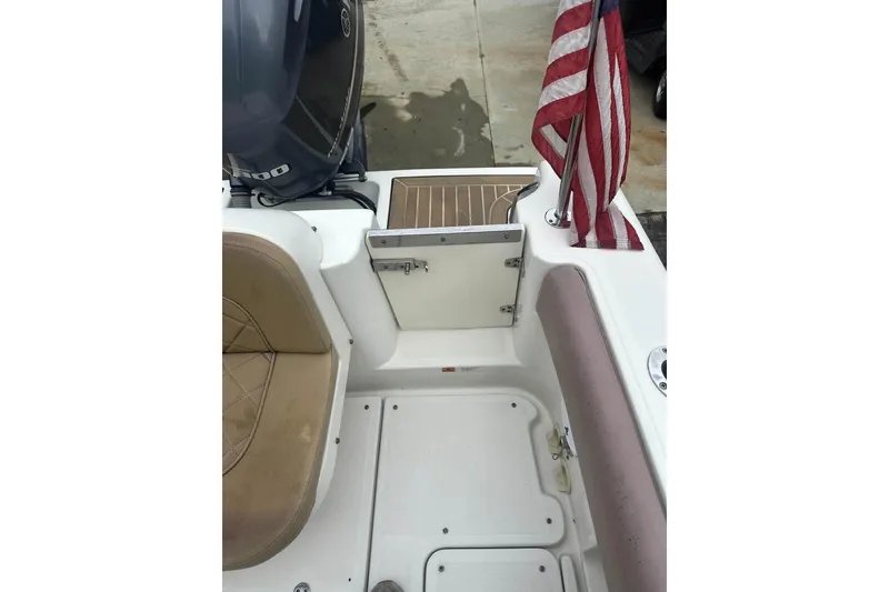 Slide: The Image of 2016 Chris-Craft Catalina 23 boat interior with seating, American flag, and engine view. - 5