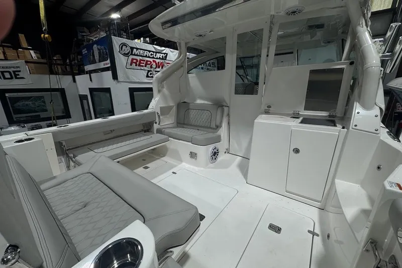 Slide: The Image of 2026 Pursuit DC 326 Dual Console interior with seating and storage in a showroom. - 11