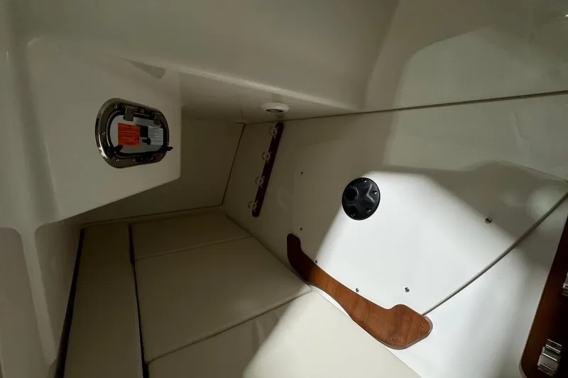 Slide: The Image of Interior cabin of 2026 Pursuit DC 326 Dual Console boat, featuring seating and storage. - 14