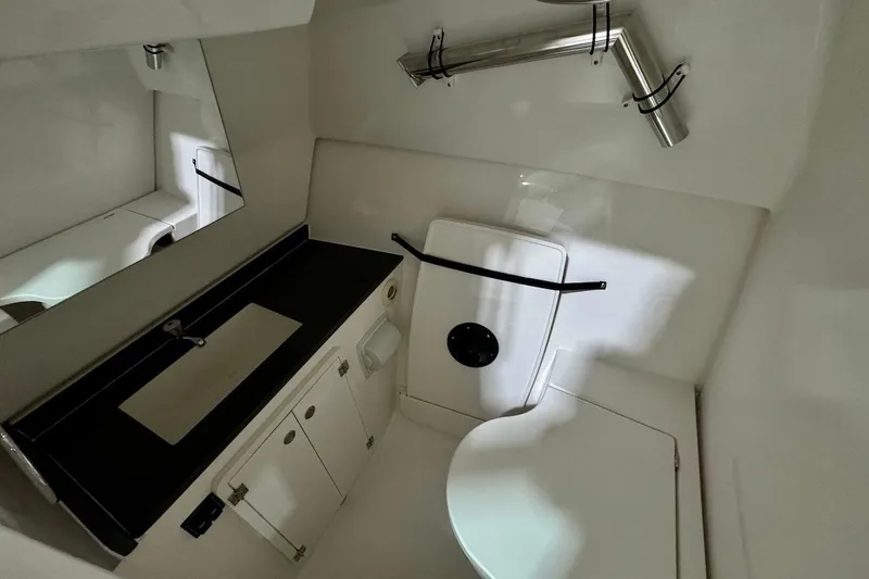 Slide: The Image of 2026 Pursuit DC 326 Dual Console boat bathroom with sink, mirror, and toilet. - 15