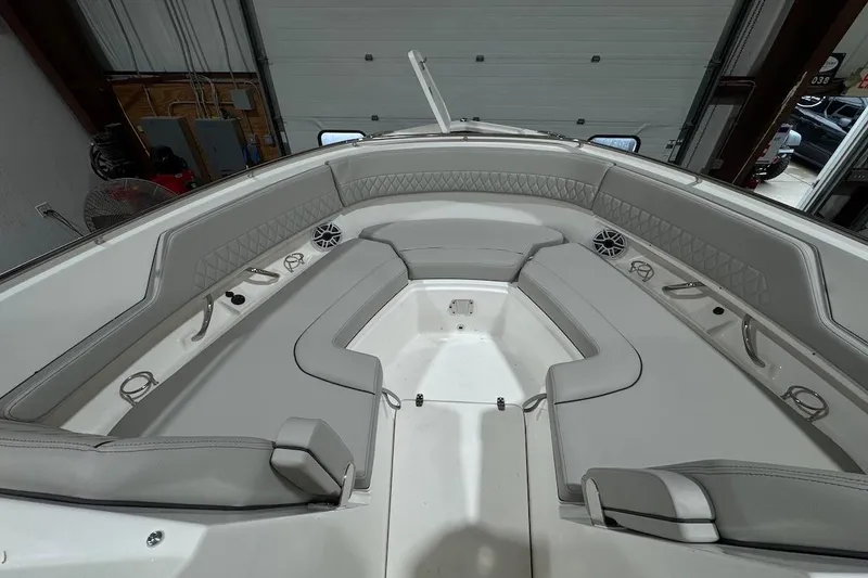 Slide: The Image of 2026 Pursuit DC 326 Dual Console boat interior with gray seating and speakers. - 18