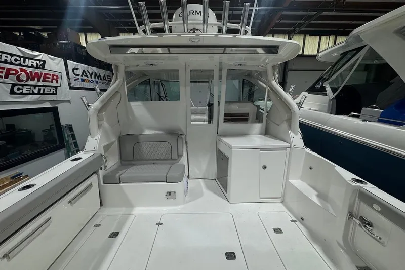 Slide: The Image of 2026 Pursuit DC 326 Dual Console boat interior, featuring seating and storage in a showroom. - 29