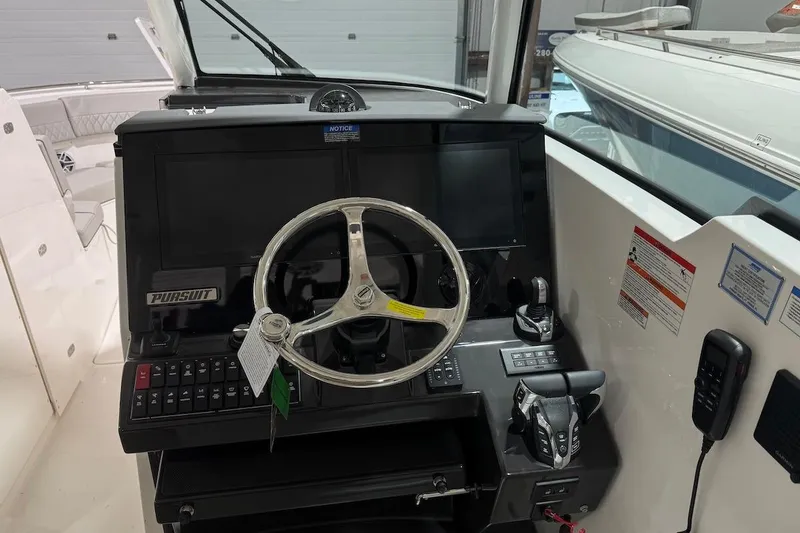 Slide: The Image of 2026 Pursuit DC 326 Dual Console boat dashboard with steering wheel and controls. - 4