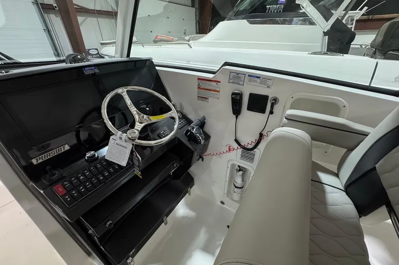 Slide: The Image of 2026 Pursuit DC 326 Dual Console boat interior with steering wheel and control panel. - 5