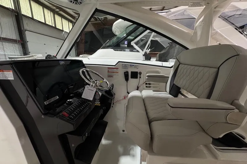 Slide: The Image of 2026 Pursuit DC 326 Dual Console interior with modern helm and comfortable seating. - 6