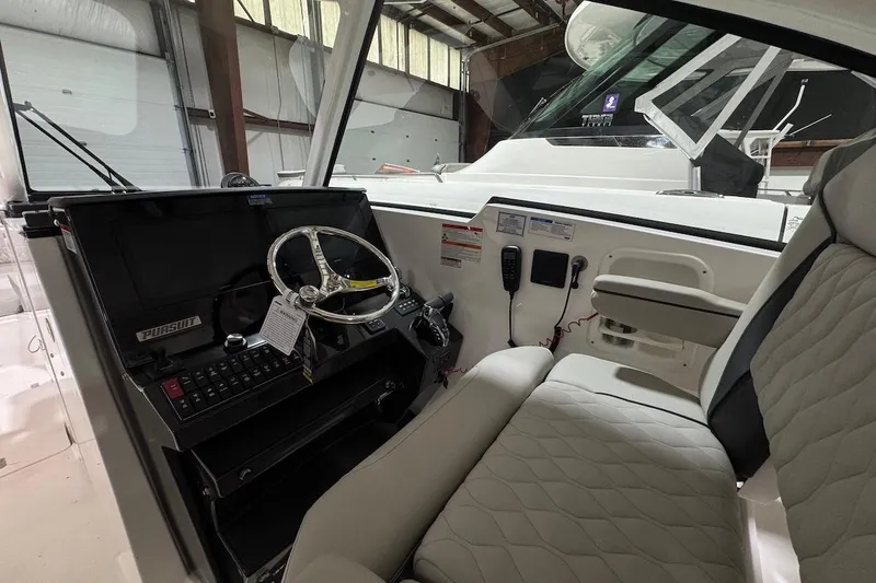 Slide: The Image of 2026 Pursuit DC 326 Dual Console interior with steering wheel and control panel. - 7