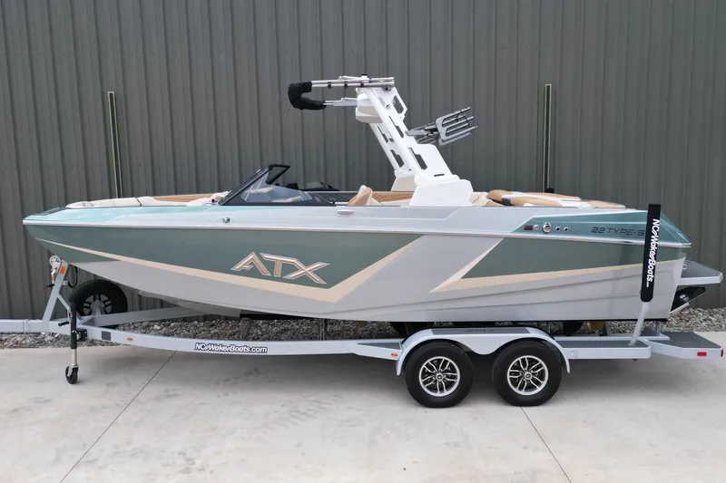 Slide: The Image of 2026 ATX Surf Boats 22 Type-S on trailer, sleek design, parked outdoors. - 2