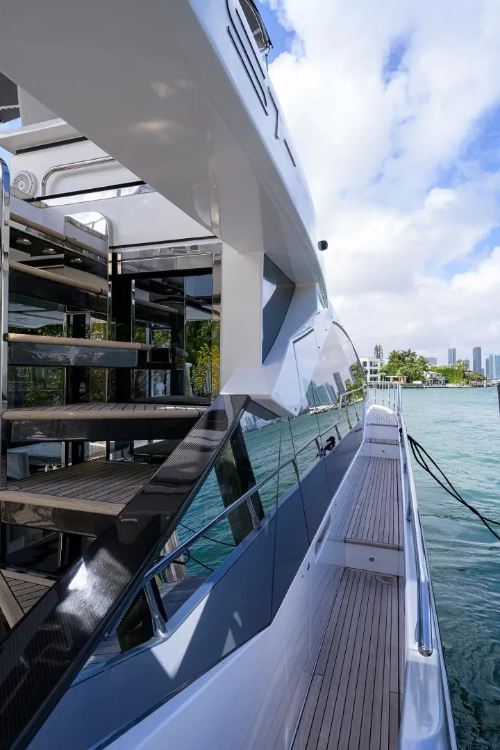 Slide: The Image of 2019 Azimut S7 yacht docked by the water with city skyline in the background. - 12