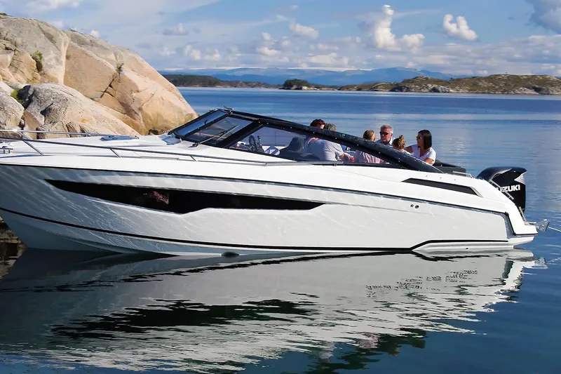 Slide: The Image of 2022 Parker Poland 850 Voyager boat on calm water near rocky shore. - 8