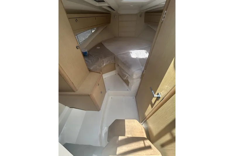 Slide: The Image of Interior cabin of 2022 Parker Poland 850 Voyager boat, featuring wooden cabinetry and a cozy bed. - 6
