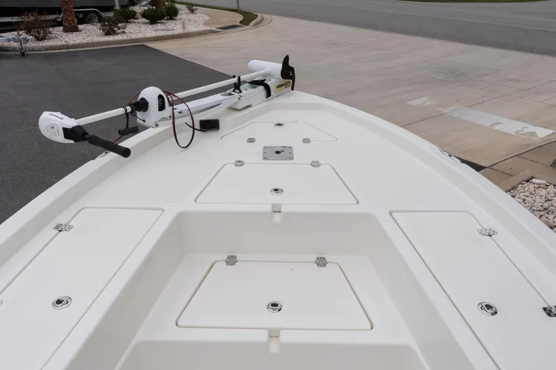 Slide: The Image of 2020 NauticStar 215 XTS boat deck with trolling motor, parked on pavement. - 12