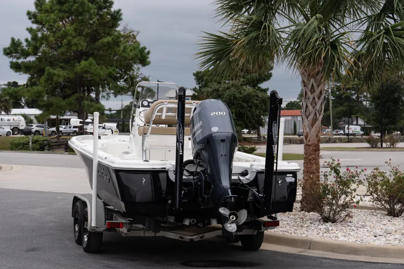 Slide: The Image of 2020 NauticStar 215 XTS boat on trailer, parked near palm trees. - 4
