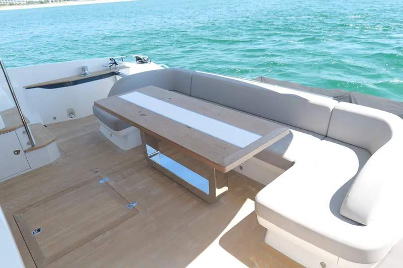 Slide: The Image of Luxurious Pearl 62 yacht deck with seating and table, 2022 model, overlooking the ocean. - 10