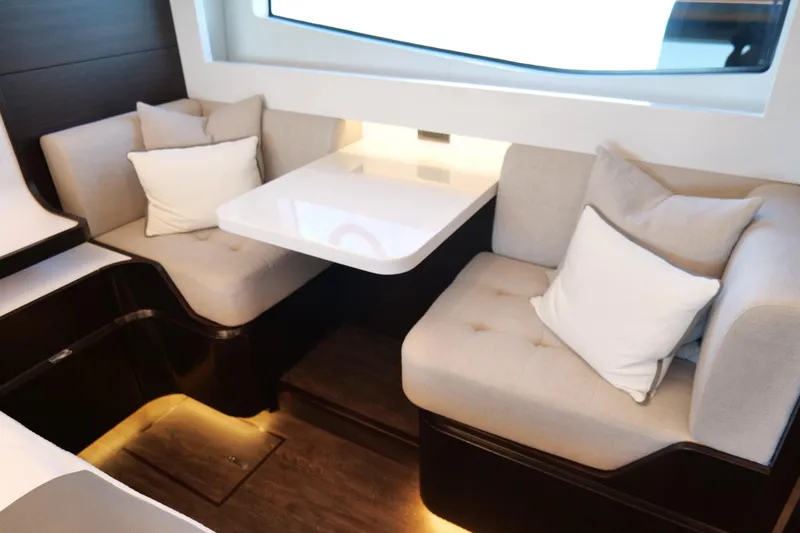 Slide: The Image of Luxurious seating area in 2022 Pearl 62 yacht with plush cushions and modern table. - 24